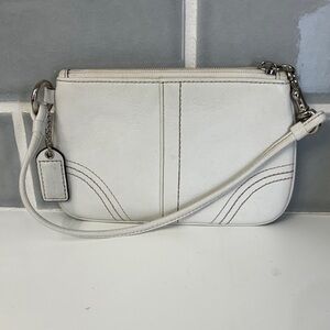 Coach Classic off-white leather wristlet featuring a small zippered wallet